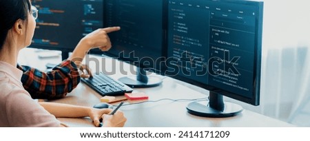 Female programer explain while pointing code displayed on computer. Professional programmer present data analysis and writing java script at modern company office. Closeup. Burgeoning. Royalty-Free Stock Photo #2414171209