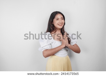Friendly Asian woman is giving gestures of traditional greetings by her hands 