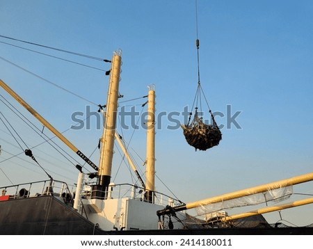 Transshipment mixed frozen Yellowfin and Skipjack tuna hang in large net, During loading and unloading from the ship hatch to factory in port area and import, export and transport cargo concept Royalty-Free Stock Photo #2414180011
