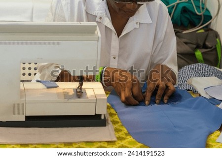 african adult black seamstress use sewing machine to skillfully sew a shirt with precision care