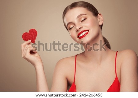 Beautiful young woman holding an artificial red heart. Valentine's Day - Holiday, Women, Valentine Card, One Woman Only, Heart Shape Royalty-Free Stock Photo #2414206453