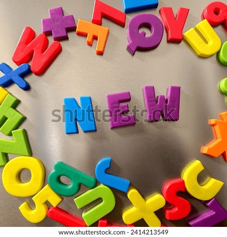 New written in Magnetic letters on a refrigerator
