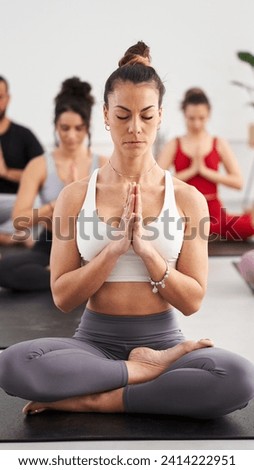 Vertical Group diverse fitness young people practicing yoga mudra exercises in class, asana posture with eyes closed. Concentrated meditating women in sportswear. Healthy and wellness in community. Royalty-Free Stock Photo #2414222951