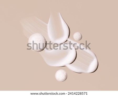 cosmetic smears of creamy texture on a beige background