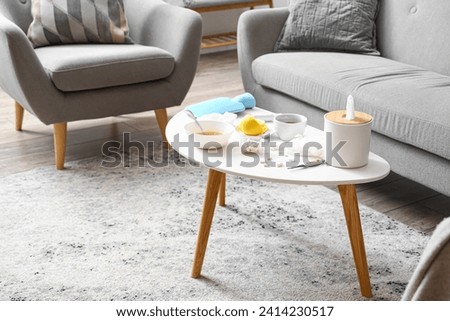 Medications with tea, lemon and soup in living room