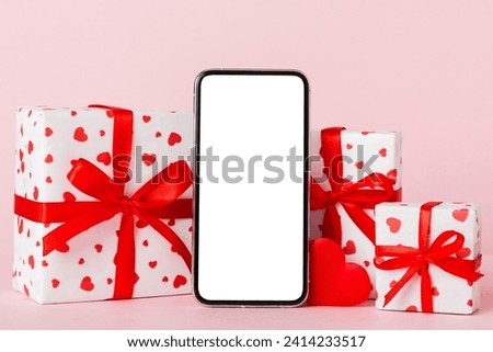mobile phone with blank screen on colored background with hearts, calendar and gift box, valentine day concept perspertive view flat lay.