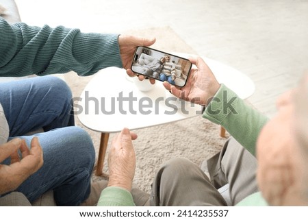 Senior female friends with their picture on mobile phone at home, closeup
