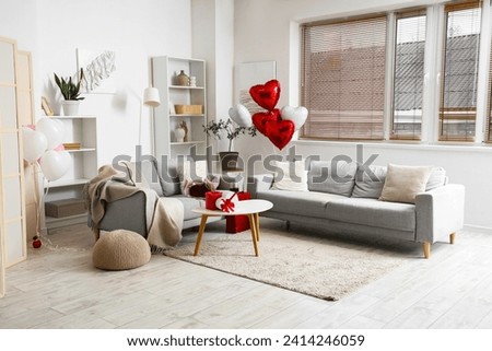 Interior of living room decorated for Valentine's Day with balloons and sofas Royalty-Free Stock Photo #2414246059