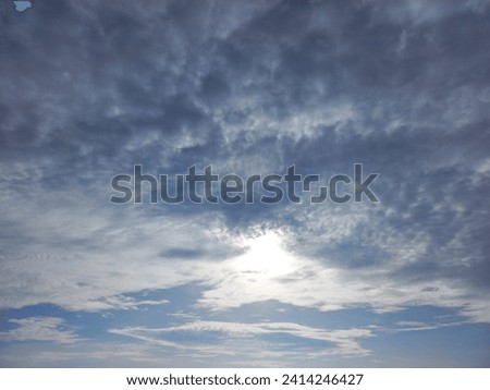 The sky is blue with white clouds and the sun at noon