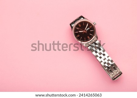 Wrist watch on pink background. Women watch. Top view