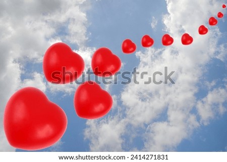 Valentine's Day concept with hearts of different sizes on sky background with clouds 
