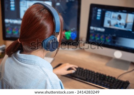 Female asian freelancer editing video for customer or travel blogger in program on computer while sitting at the table and working at home