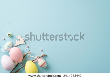 Radiate Easter vibes with this enchanting top view picture displaying lively eggs, sweet bunny, pussy willow, sugar sprinkles, on pastel blue background. Ample space for your text or promo content