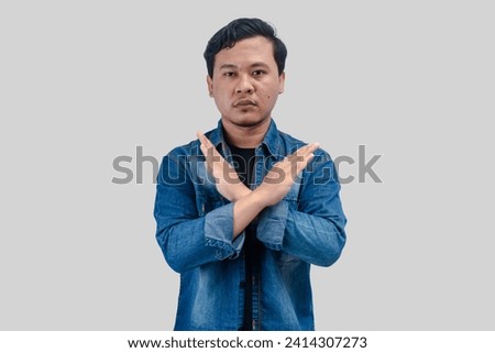 Young Asian Man unhappy or confident standing wear holding two cross arms say no X sign, On isolated background Royalty-Free Stock Photo #2414307273