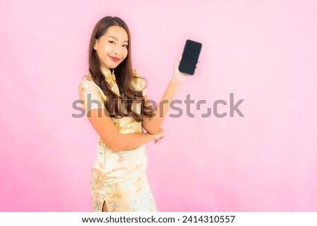 Portrait beautiful young asian woman with smart mobile phone on pink color background