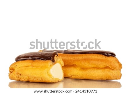 One whole and one half delicious chocolate eclair, close-up isolated on white. Royalty-Free Stock Photo #2414310971