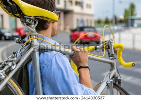 Man carrying his racing cycle on shoulder Royalty-Free Stock Photo #2414330537