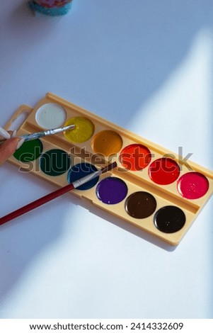 Back to school concept watercolor pallet. Art palette with paint and brushes top view on white background