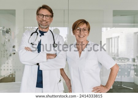 Portrait of confident doctor and assistant in medical practice Royalty-Free Stock Photo #2414333815