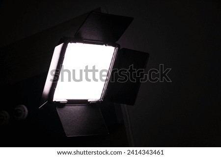 LED video light with barndoors with bright light and dark background