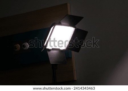 LED video light with barndoors with bright light and dark background