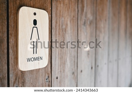 close up toilet sign for woman on wood wall