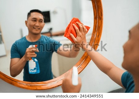 cropped blurred view of man cleans and wipes mirror