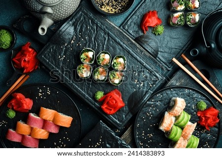 sushi rolls with salmon, kale leaves, and cream cheese. Served with wasabi sauce and pickled ginger. Japanese traditional food. Close up.