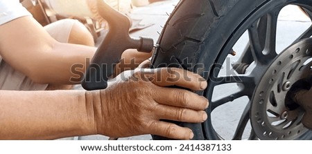 Technician patching a tire motorcycle tires Royalty-Free Stock Photo #2414387133