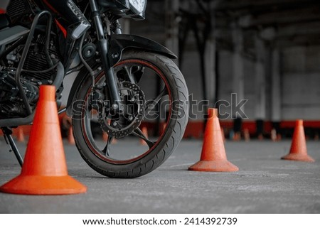 Closeup view on wheel of training motorcycle at driving school motordrome Royalty-Free Stock Photo #2414392739
