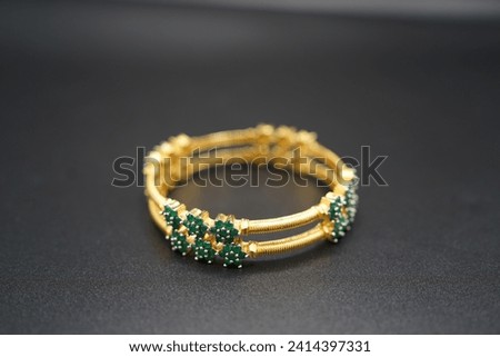 Green Gem Gold Bracelet with box on a black background  Royalty-Free Stock Photo #2414397331