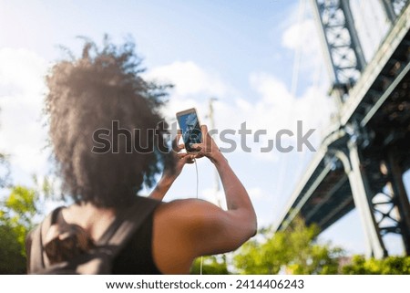 Usa- new york city- brooklyn- woman taking cell phone picture of manhattan bridge