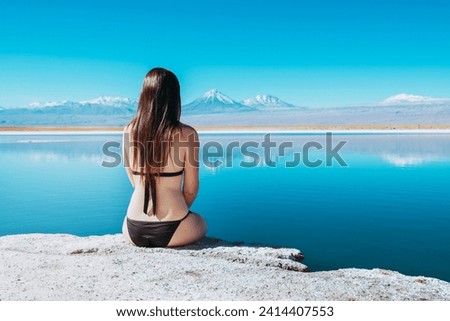Chile- atacama desert- back view of woman sitting on edge of laguna cejar Royalty-Free Stock Photo #2414407553