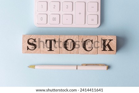 STOCK on a wooden cubes with pen and calculator, financial concept