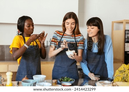 Friends taking smartphone pictures in a cooking workshop