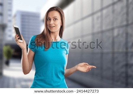 Happy young woman hold phone in the city street