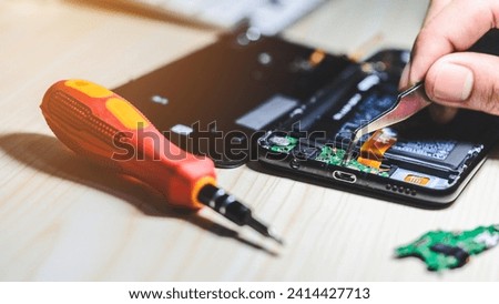 Technician or repairman repairing the smartphone's motherboard in the lab. the concept of phone repair, computer hardware, mobile phone, electronic, repairing