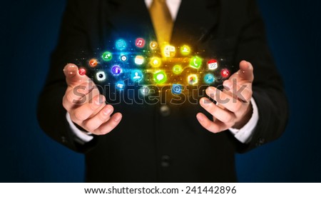 Businessman holding a shining app icon cloud in front of his body 