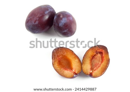 Juicy summer plum fruit. Two whole fruit and Halves ripe sweet plums isolated on white background. 
