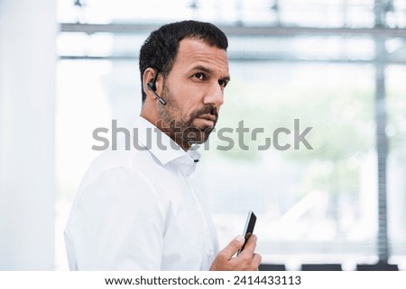 Businessman using smartphone and headset