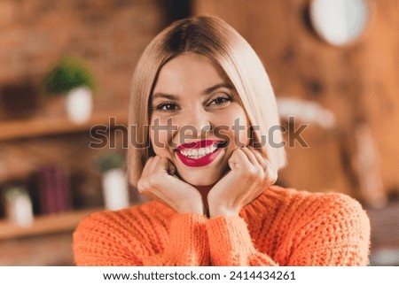 Photo of stunning positive lady arms touch cheekbones beaming smile comfy atmosphere apartment inside
