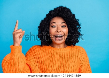 Photo portrait of pretty young girl excited discovery point up wear trendy knitwear orange outfit isolated on blue color background
