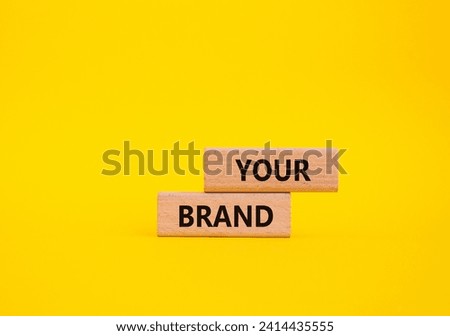 Your Brand symbol. Concept word Your Brand on wooden blocks. Beautiful yellow background. Business and Your Brand concept. Copy space
