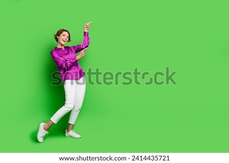 Full length photo of charming young attractive promoter woman pointing fingers empty space taxi service isolated on green color background