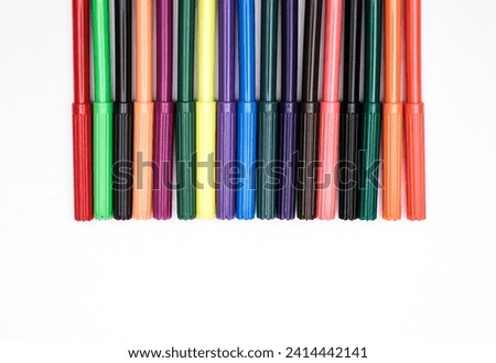 A group of coloured pens on a white surface