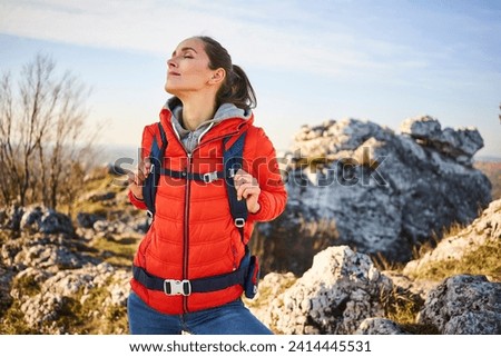 Woman on a hiking trip in the mountains having a break Royalty-Free Stock Photo #2414445531