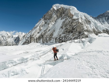 Nepal- solo khumbu- everest- sagamartha national park- mountaineer crossing icefall at western cwm Royalty-Free Stock Photo #2414449219