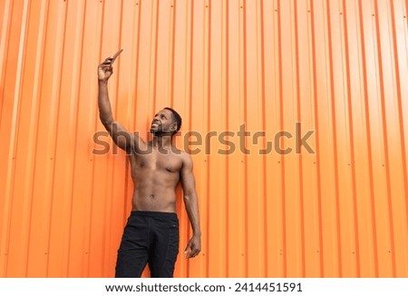 Portrait of athlete taking a selfie in front of an orange wall