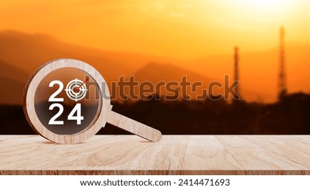 2024 year number with Target icon inside the wooden magnifying glass on industry background, business concept banner, Planning for goal and success concepts.