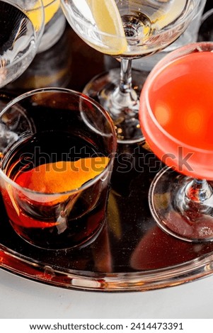 Cocktails. Traditional American drinks made by artisanal bartenders in speakeasy and upscale bars or dives or taverns.Cocktails served in chilled cocktail glasses and garnished with fruit.